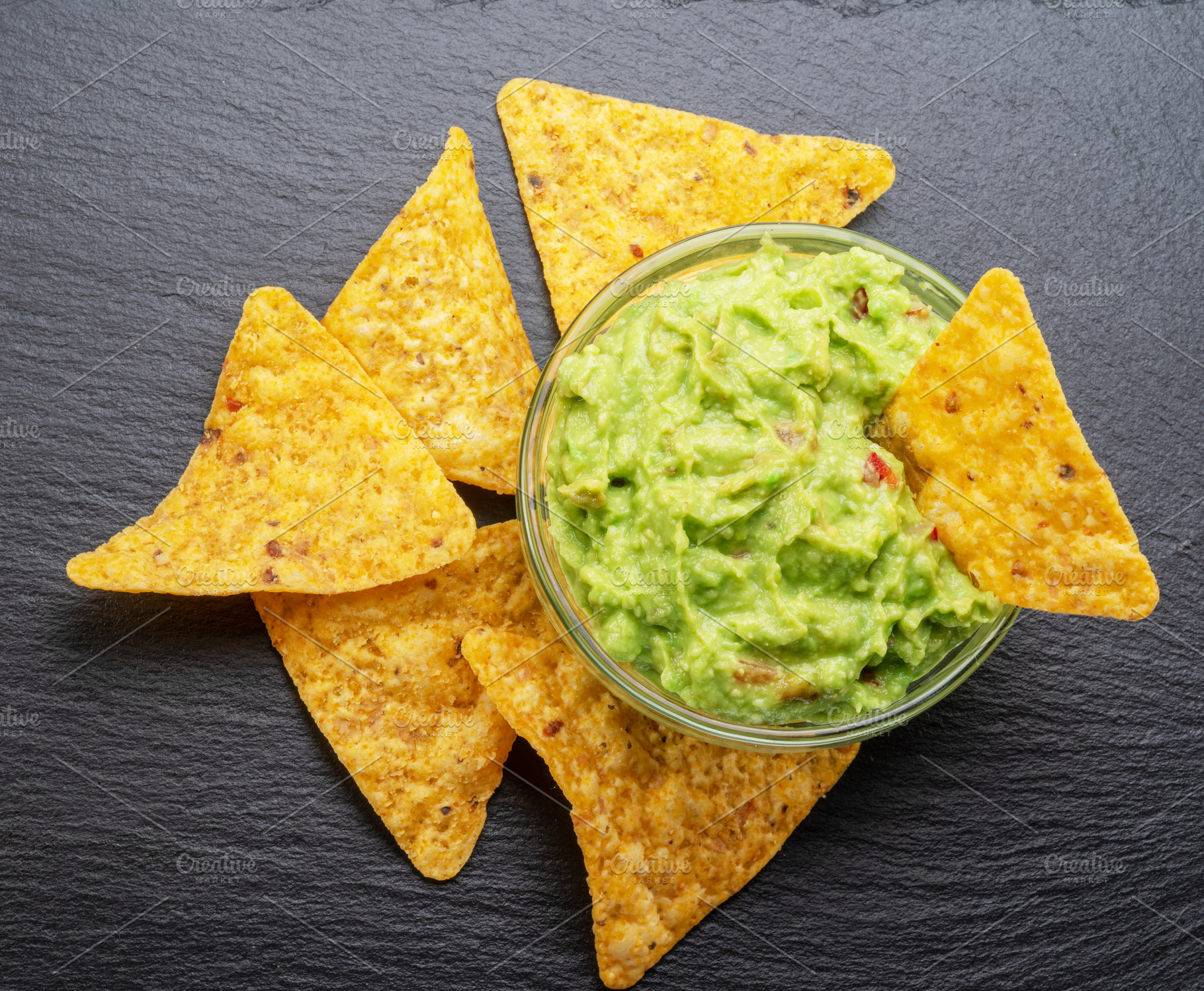Guacamole sauce and tortilla chips, popular Mexican food, on sla, a Food & Drink Photo by Volff
