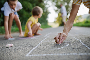 Mom and kids drawing with chalk on, a Person Photo by HalfPoint
