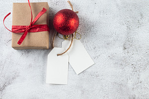 Empty tag with gifts and red Christmas decor on grey conkrete ba, a Holiday Photo by vimart