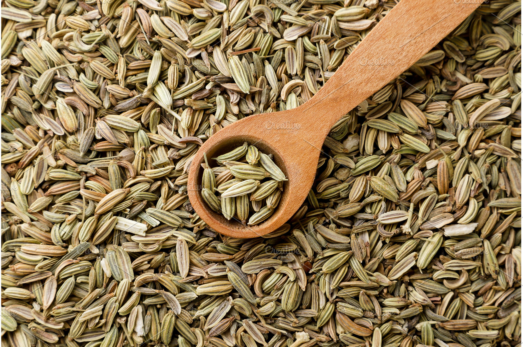 Fennel seeds in a wooden spoon, a Food & Drink Photo by innakreativ