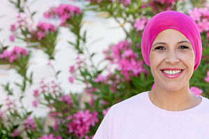 Smiling Breast Cancer Survivor in Pink Headscarf with Garden Flo, a Person Photo by José Manuel Gelpi