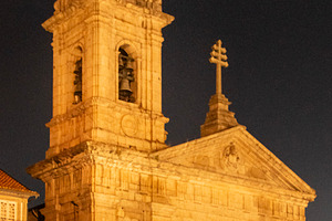 Illuminated church tower and historic buildings in main square,, a Photo by DanFLCreativo