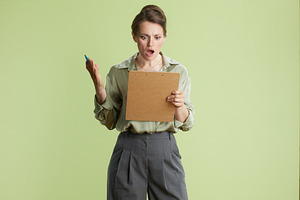Surprised woman with clipboard, a Person Photo by Alliance Images