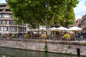 Outdoor café along the canal in Strasbourg France, an Architecture Photo by GoodGoods