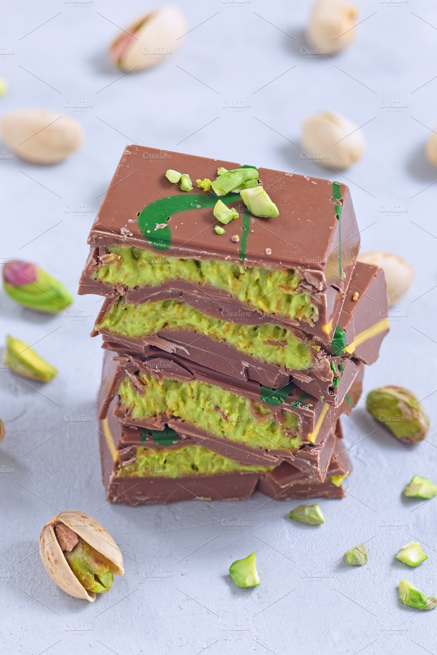Stack of pistachio Dubai style chocolate bars with whole pistachios showing fil, a Food & Drink Photo by iuliia_n
