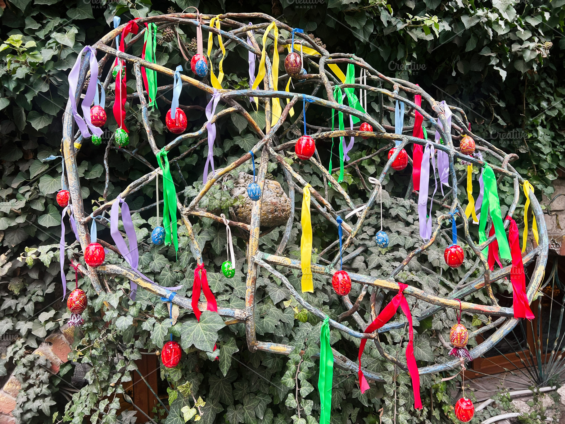 Colorful ribbons and ornaments decorating a spherical metal structure in a gard, a Photo by AS photostudio