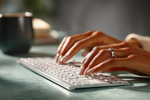Woman's hands typing on a wireless k, a Photo by Pixeness Studio