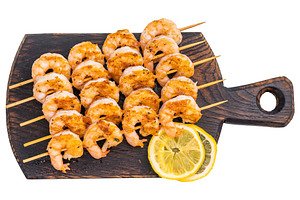 Grilled shrimp skewers served on a rustic dark cutting board wit, a Food & Drink Photo by composter-box@mail.ru