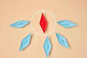 Leadership and individuality concept. One red origami boat surro, an Abstract Photo by ndanko
