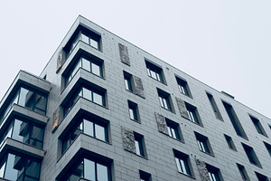 Modern architectural building with large windows and textured facade, an Industrial Photo by Textures & Backgrounds