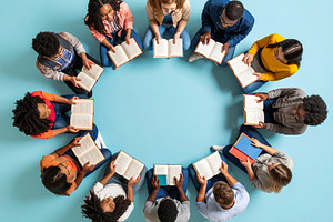 Diverse students holding books forming a circle at classroom gro, a School & Education Photo by DanFLCreativo