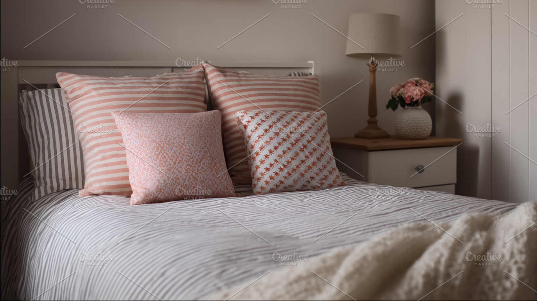 Cozy bedroom interior featuring various pillows with stripes and, a Photo by Studio ANNA