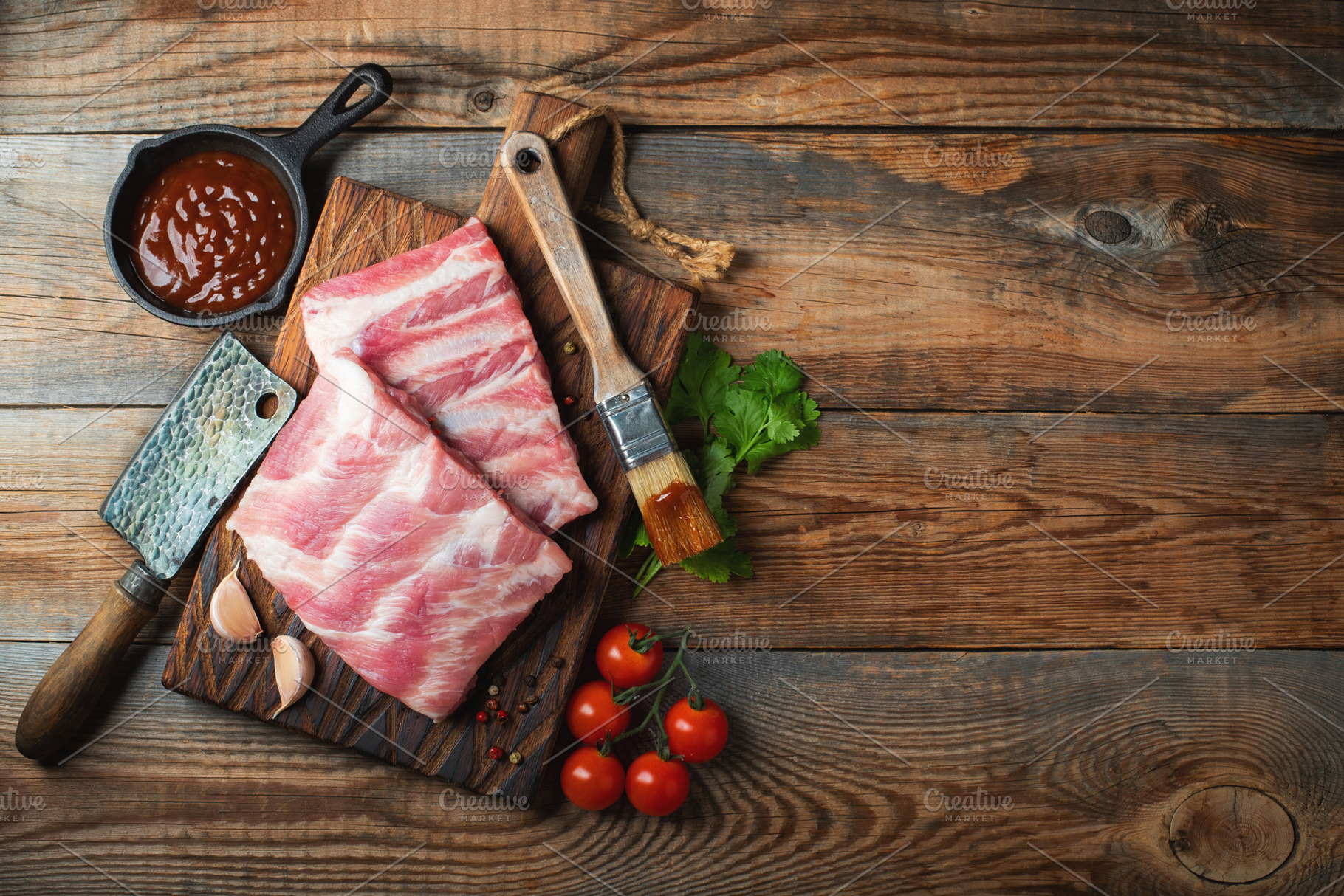Raw pork ribs with spices, salt and rosemary on dark wooden background, a Food & Drink Photo by Budarinphoto