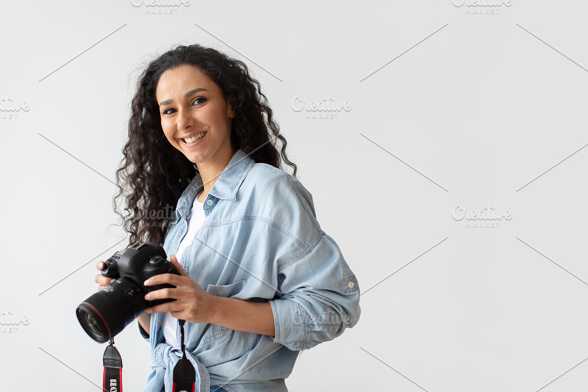 Photographer Woman Holding Photo Camera Posing Over White Wall, a Photo by Prostock-Studio (Photo 4 of 4)