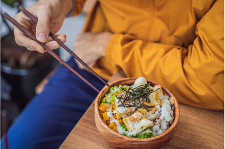 Man eating Raw Organic Poke Bowl, a Food & Drink Photo by Elizaveta Galitskaya