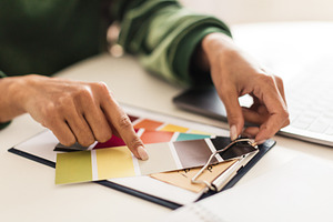 Closeup Of Female Hands Holding And Choosing Color Palettes Indoor, a Photo by Prostock-Studio