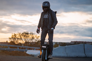 A man rides on an electric unicycle. Mono Wheel riding (EUC) , protective gear