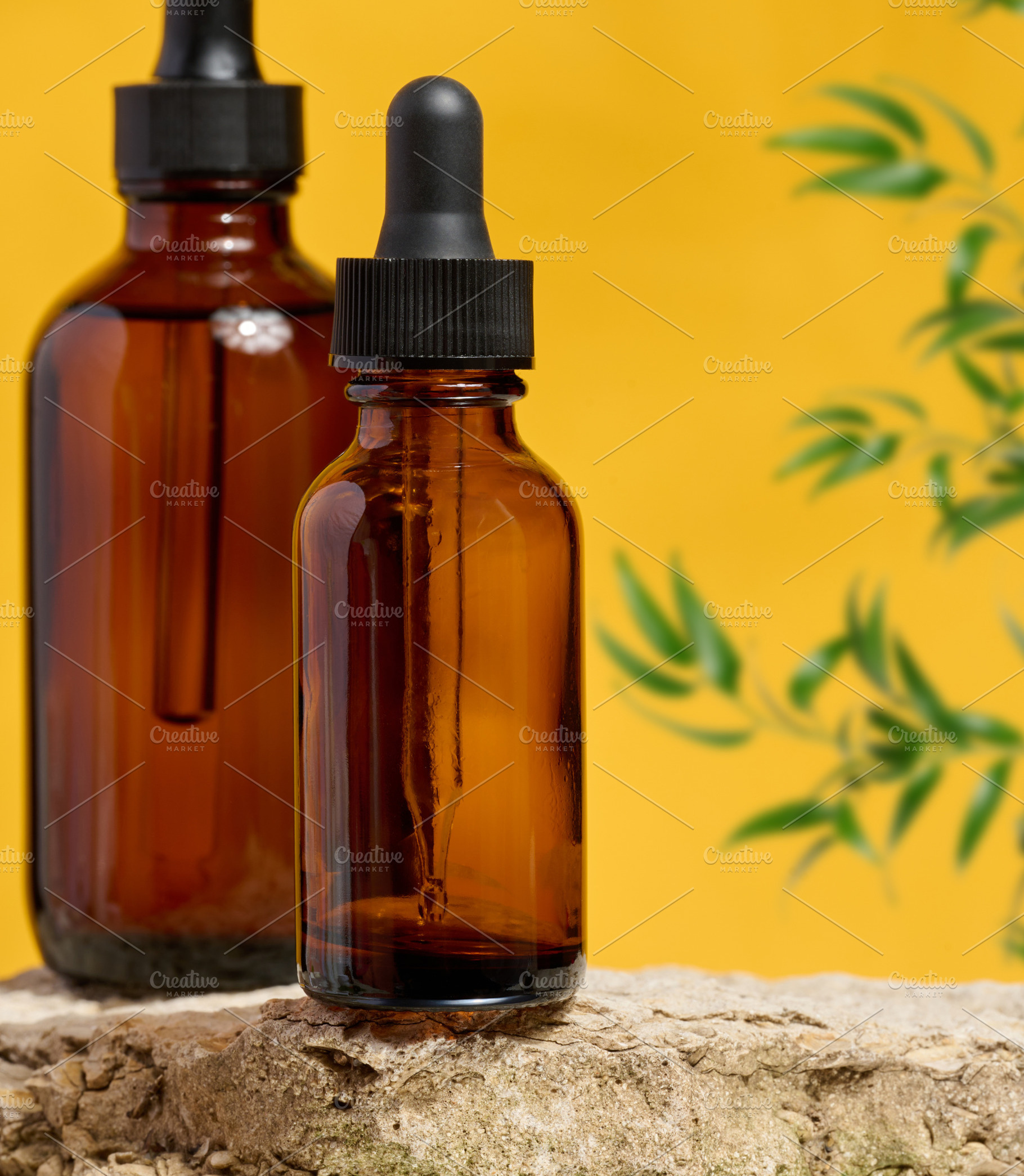Amber glass dropper bottles on a natural stone surface with a ye, a Health & Medical Photo by ndanko
