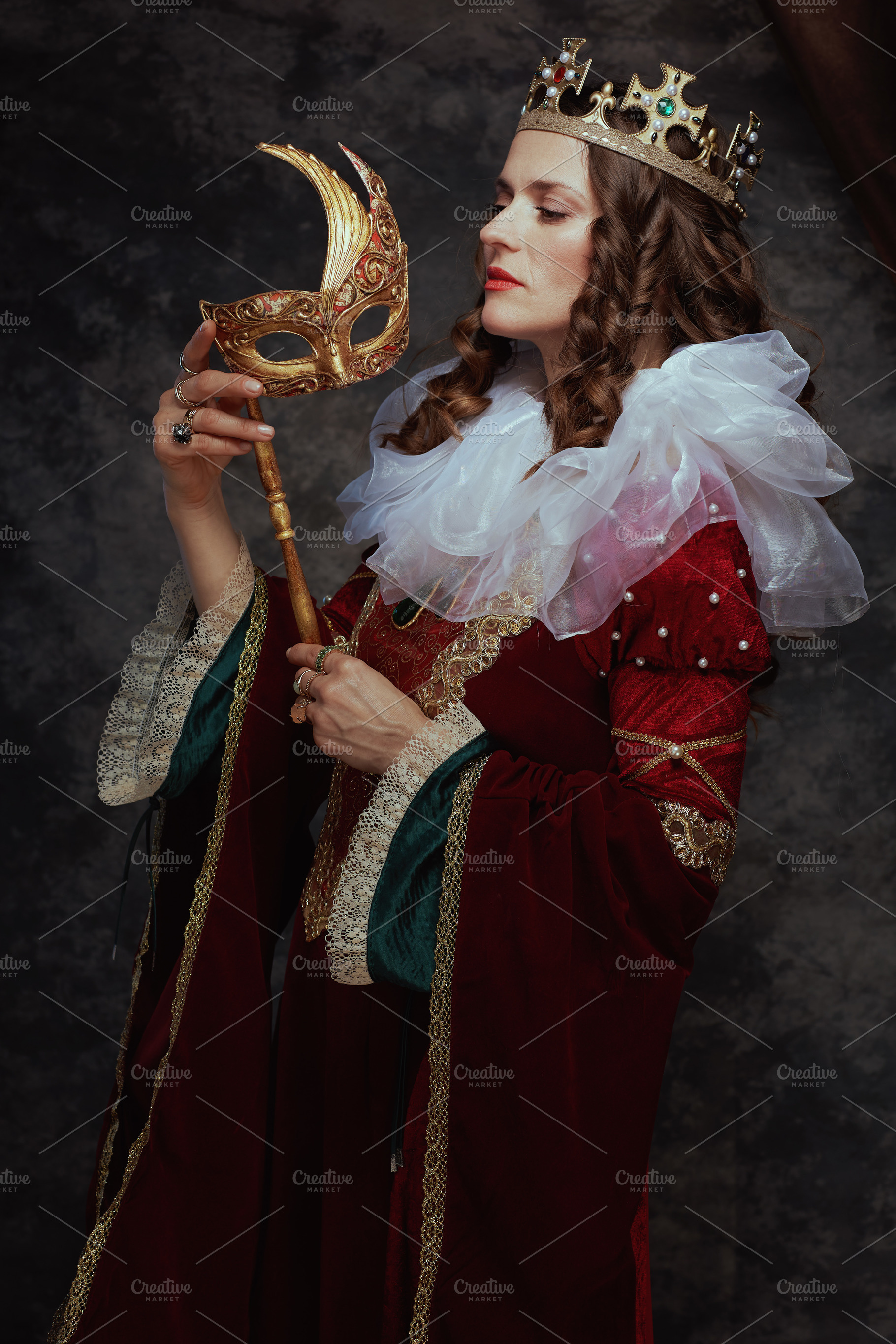 medieval queen in red dress with venetian mask, a Person Photo by Alliance Images