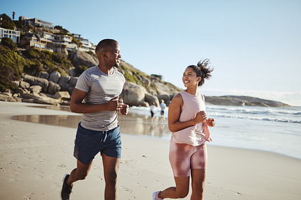 Couple, fitness and running with smile at the beach, exercise and cardio, happiness and active lifestyle. Young, happy people, runner and health, body training and motivation workout outdoor at ocean, a Photo by Peopleimages.com