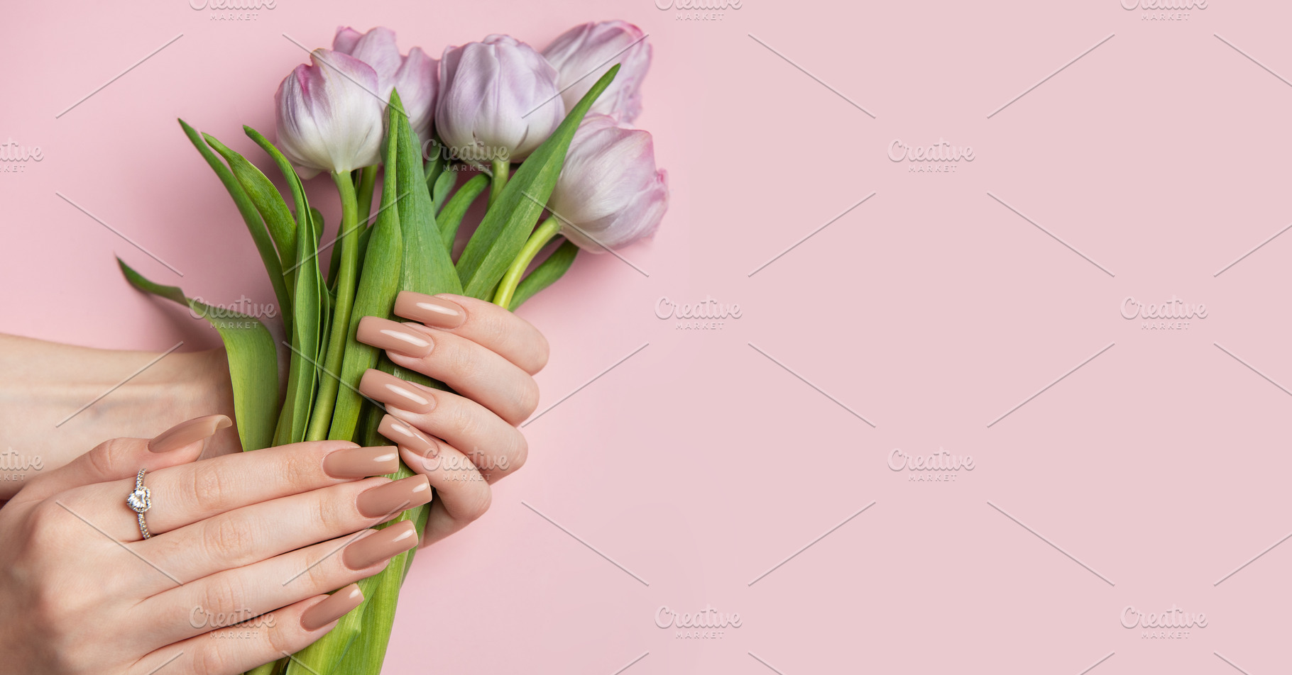 Woman holding bouquet of purple tulips showing manicure on pink, a Beauty & Fashion Photo by Olena Rudo
