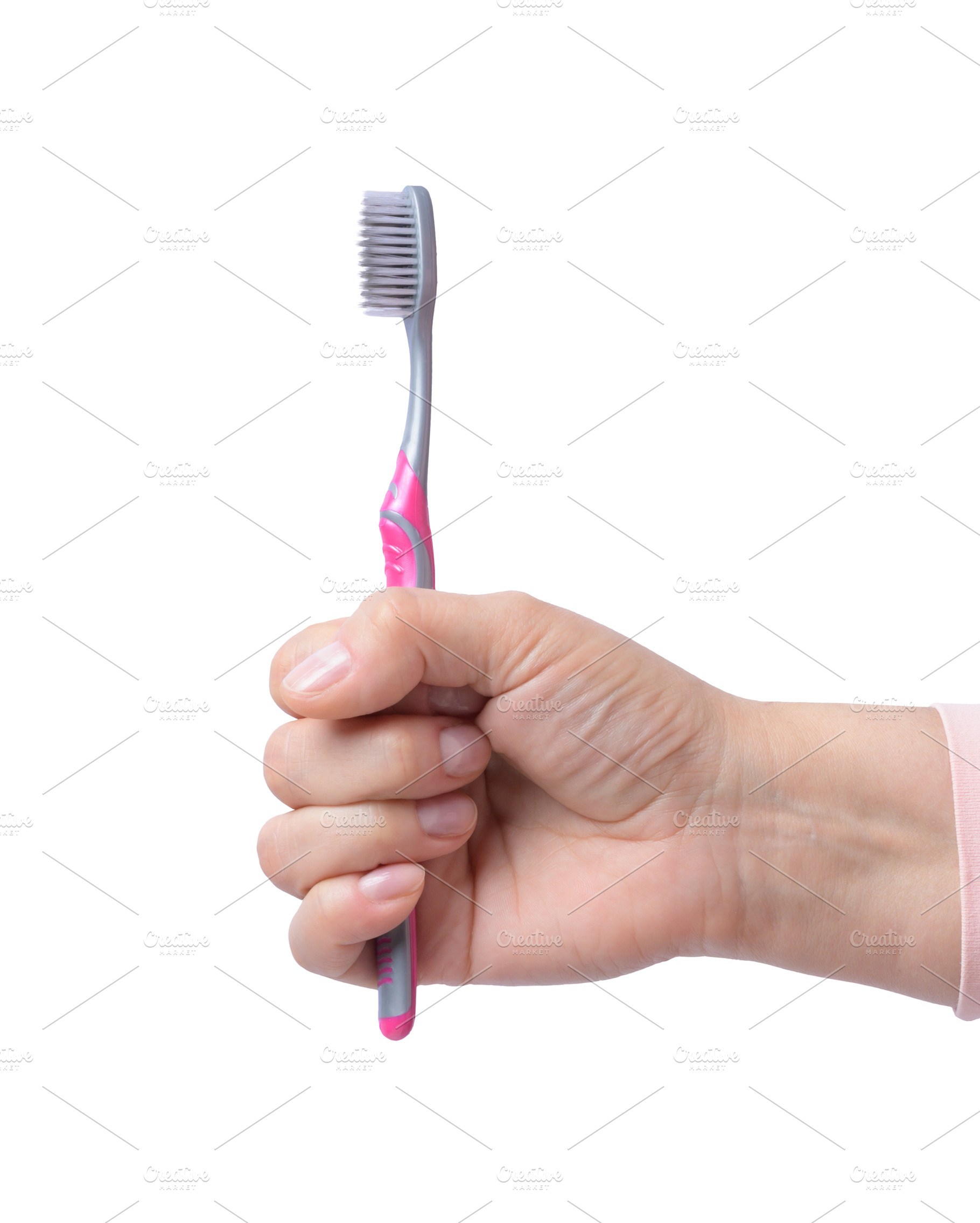 Female hand holding toothbrush on isolated background, a Person Photo by ndanko