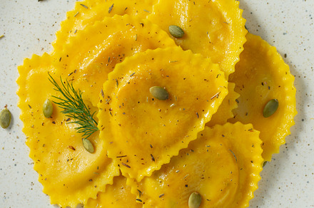 Homemade Pumpkin Ravioli with butter on a dark concrete background. Top view, a Food & Drink Photo by Budarinphoto