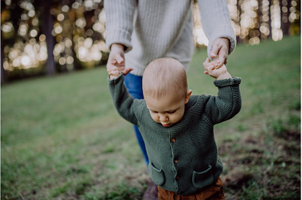 Mother holding hands of her baby son, a Nature Photo by HalfPoint