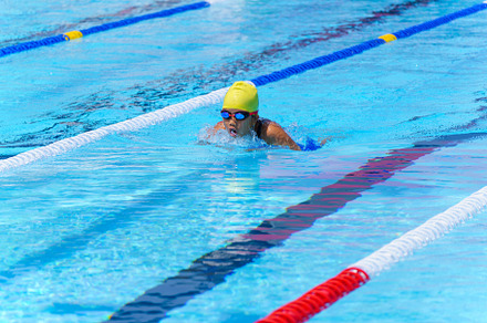 Swimmer child swims breaststroke swimming style in a race swimmi