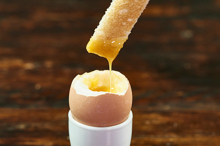 Hand Dipping Toast In Egg