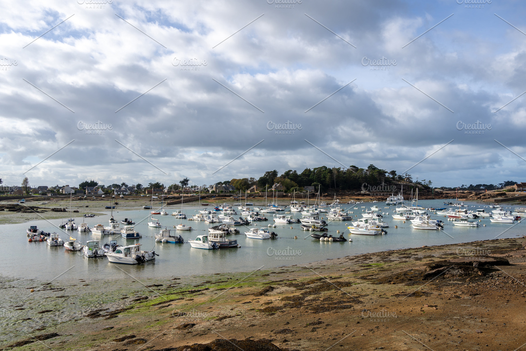 Ploumanach harbor filled with boats under cloudy sky in Brittany, a Transportation Photo by GoodGoods