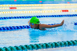 Swimmer child swims butterfly swimming style in a race swimming