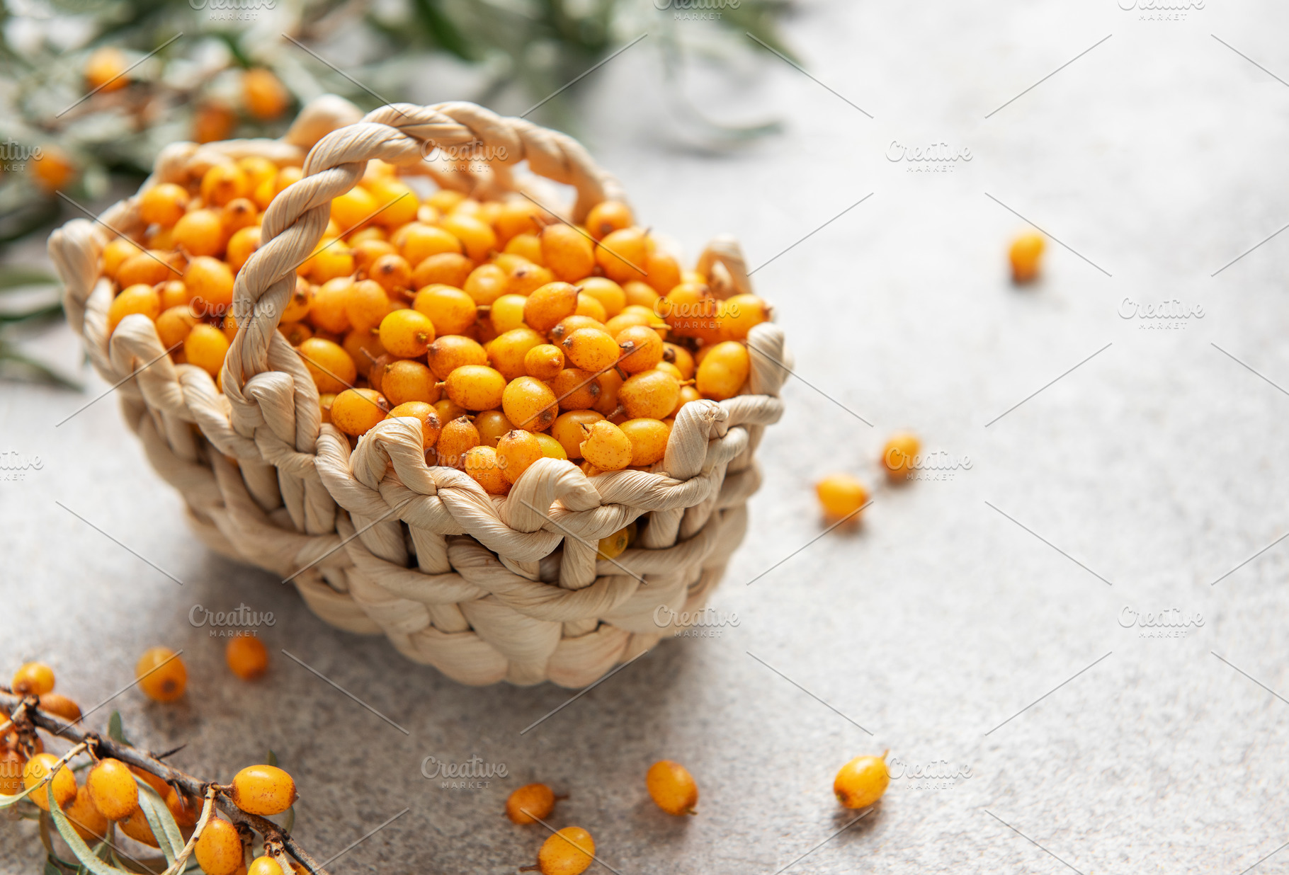 Fresh sea buckthorn berries overflowing a small basket on a text, a Food & Drink Photo by Olena Rudo