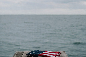 a folded US flag near the pier edge, generative AI, a Photo by Nito