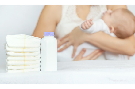 mother changes baby's diaper on a, a Person Photo by yanadjana