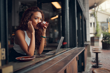 Young woman, content and drink coffee at cafe for relax, peaceful and focused on work with laptop. Female, girl and hot beverage or tea in hand take a break, for lunch and thinking in coffee shop., a Photo by Peopleimages.com
