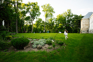 Children playing on a grassy hill amidst trees and natural surroundings, a Photo by AS photostudio