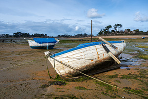 Old weathered boat beached on tidal flats in Tregastel, France, a Transportation Photo by GoodGoods
