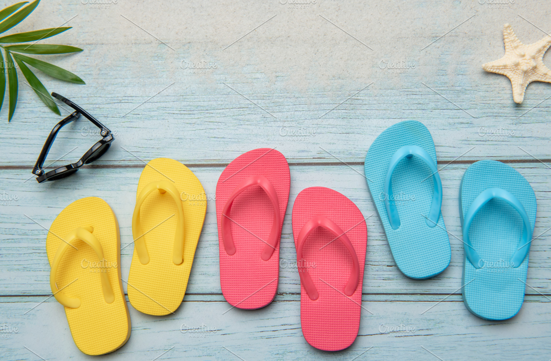 Colorful flip flops and sunglasses resting on beach boardwalk, e, a Holiday Photo by Olena Rudo