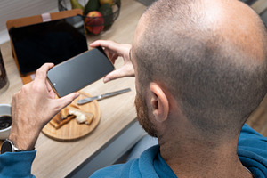 Man taking a photo of breakfast with his phone, a Food & Drink Photo by etorres69