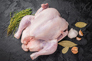 Raw whole chicken with fresh thyme and garlic cloves on a dark,, a Photo by composter-box@mail.ru