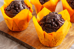 Homemade Chocolate Chip Muffins on a wooden board, side view. Cl, a Food & Drink Photo by LiudmylaChuhunova