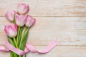 Pink tulips tied with pink ribbon lying on white wooden backgrou, a Holiday Photo by Olena Rudo