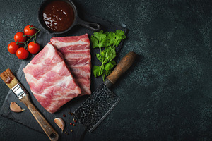 Raw meat. Raw pork ribs from the back with meat on a black background. backgrou, a Food & Drink Photo by Budarinphoto