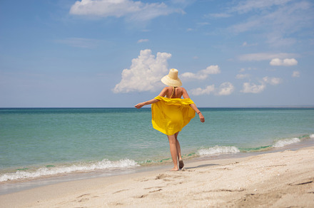 young fashionable woman in a yellow hat dress and sun glasses is posing on beac, a Person Photo by SaulichPhoto