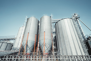 Grain silos under blue sky, an Industrial Photo by SkyNext