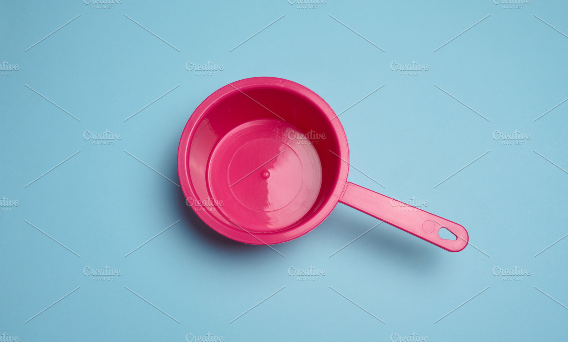 Empty pink plastic ladle on blue background, a Food & Drink Photo by ndanko