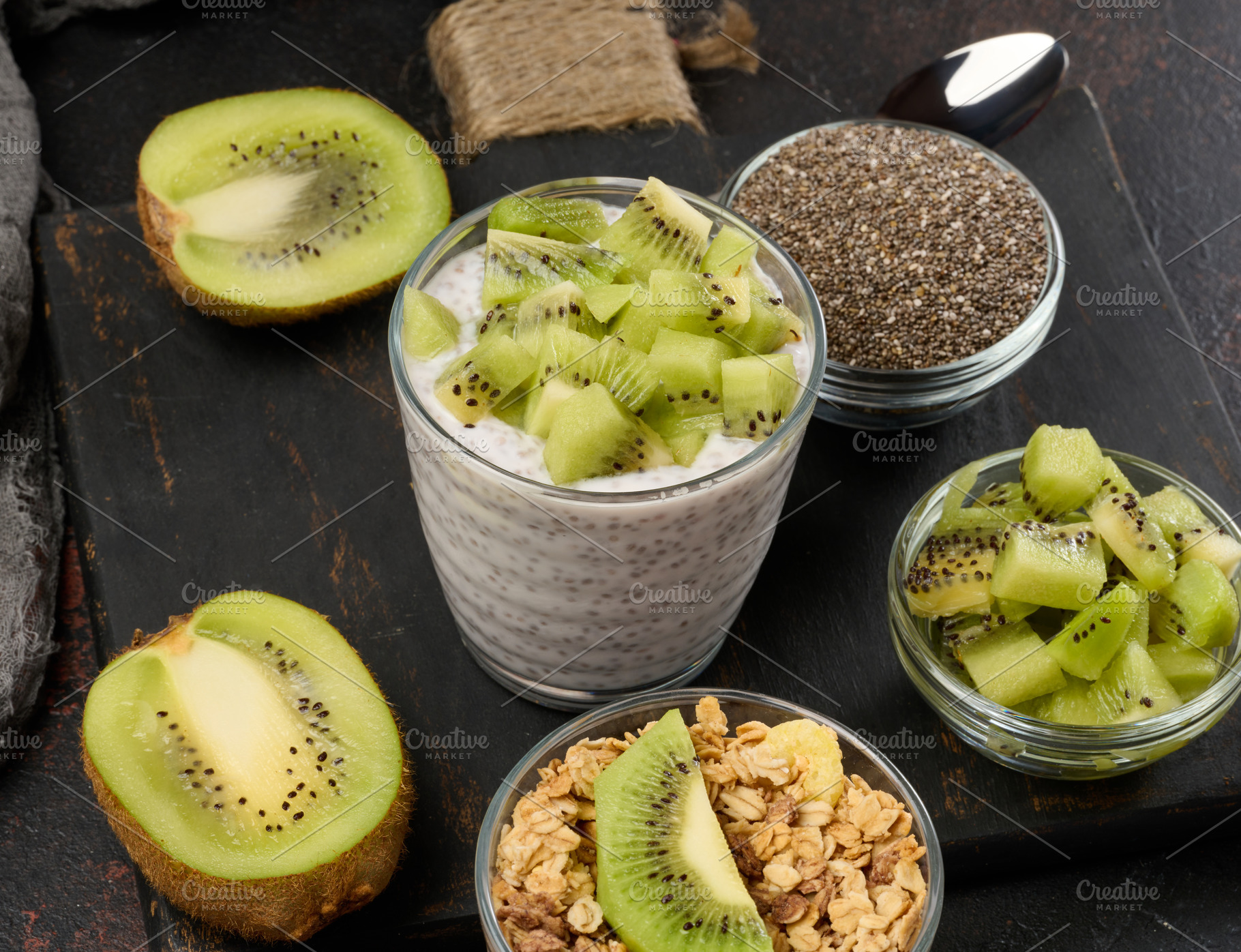 Glass of chia seed pudding mixed with diced kiwi is on a black s, a Food & Drink Photo by ndanko