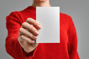 Vertical Postcard Mockup in Hand, a Person Photo by Virgo Studio