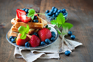 Belgian waffles with berries featuring strawberry, blueberry, and maple